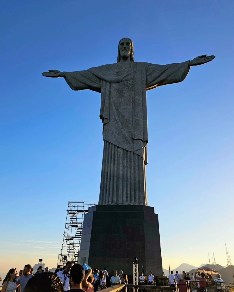 a crowd of people standing around a large statue - Rio de Janeiro