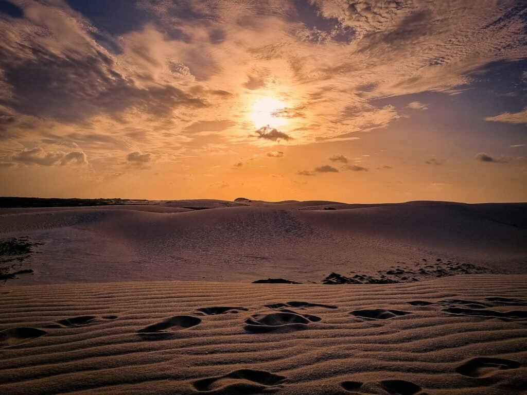 the sun is setting over the sand dunes Praias